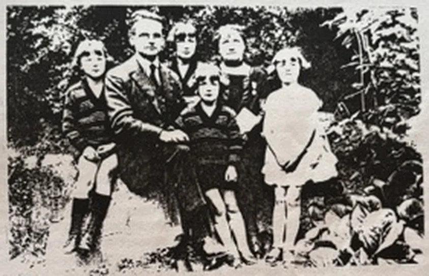 Famille réunie en plein air devant un massif de verdure