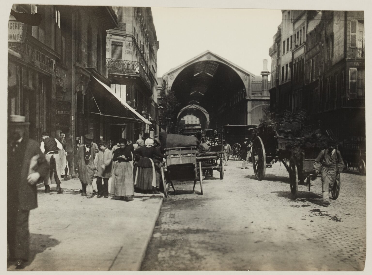 La rue de la Cossonnerie vers 1890, photographiée par Hippolyte Blancard : façades anciennes et pavillons des Halles de Baltard au fond.
